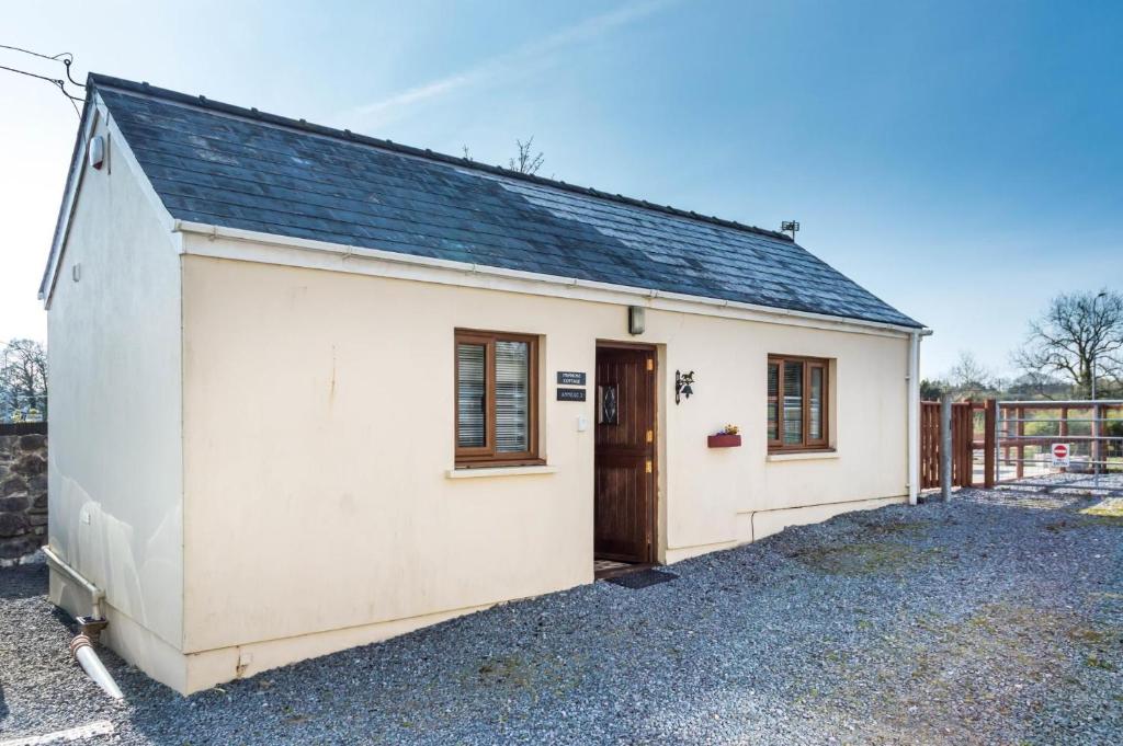a small white shed with a door and windows at Primrose - 1 Bedroom Cottage - Llanteg in Crunwear