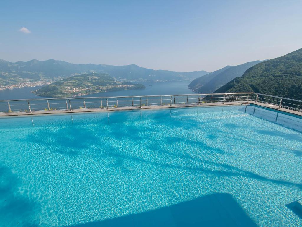 a large swimming pool with a view of the water at Van Gogh - beautiful lake Iseo view and swimming pool in Parzanica