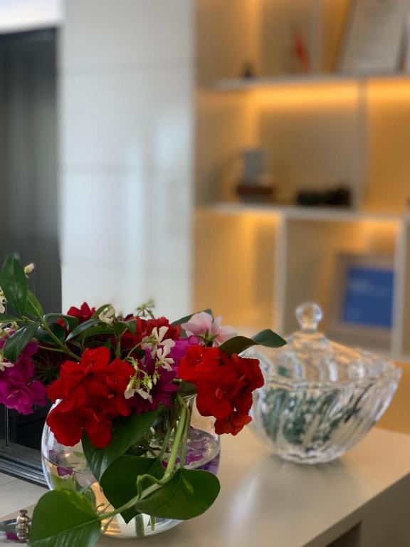 a vase filled with red flowers sitting on a table at Iliad Hotel in Durrës