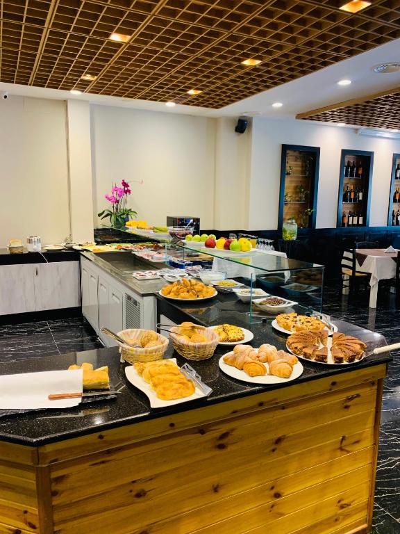 a buffet with many plates of food on a counter at Iliad Hotel in Durrës