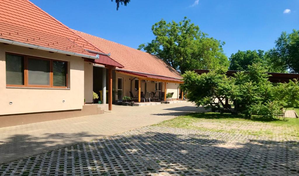 una casa con techo rojo y algunos árboles en Léna Vendégház, en Balatonberény