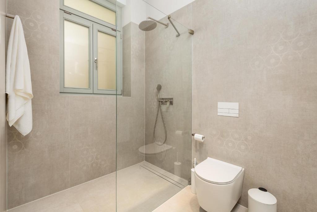 a bathroom with a toilet and a glass shower at Plaza Apartments in Opatija