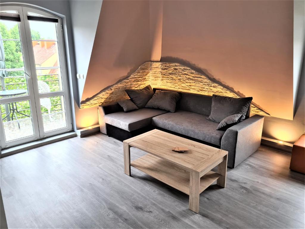 a living room with a couch and a coffee table at Yakuzza Apartments in Giżycko