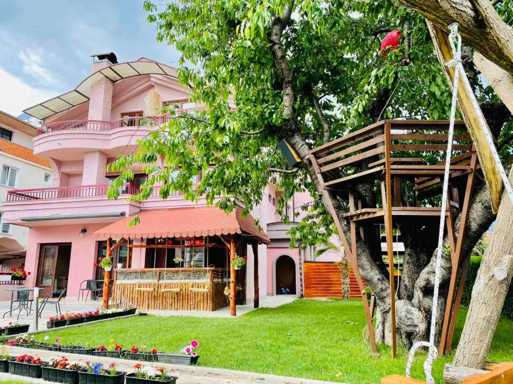 ein rosa Haus mit einem Baum davor in der Unterkunft Villa Cherry in Struga