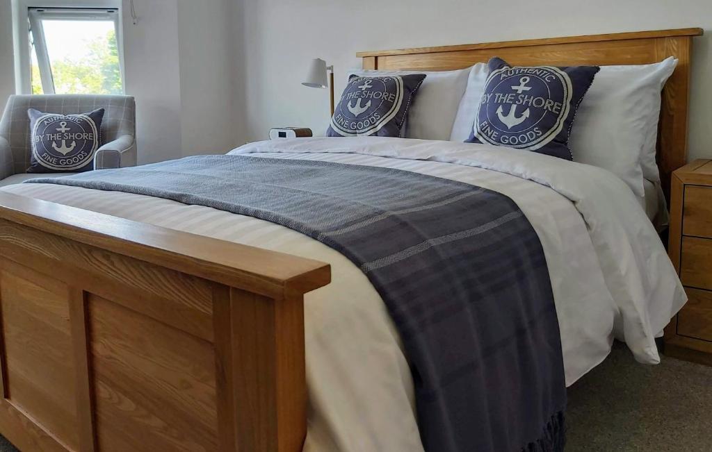 uma cama com um cobertor e almofadas azuis e brancas em Viva Guest House em Clacton-on-Sea