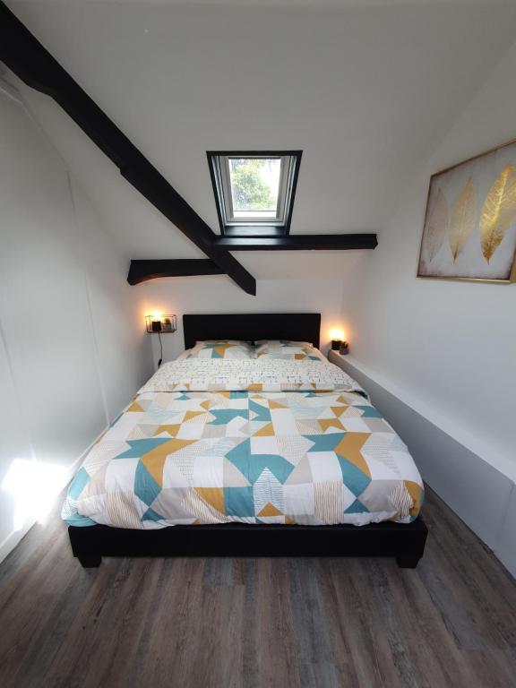 a bedroom with a bed with a colorful quilt at Lodge de la Gare Vue Cathédrale in Rouen