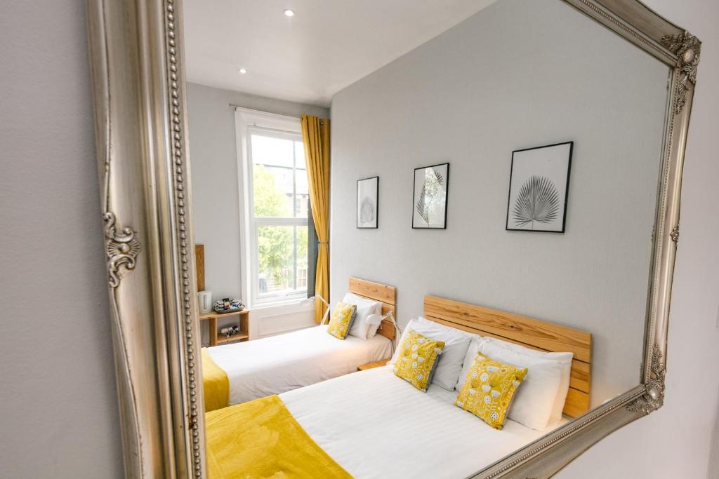 einen Spiegel in einem Schlafzimmer mit 2 Betten in der Unterkunft Kenilworth Hotel in Newcastle upon Tyne