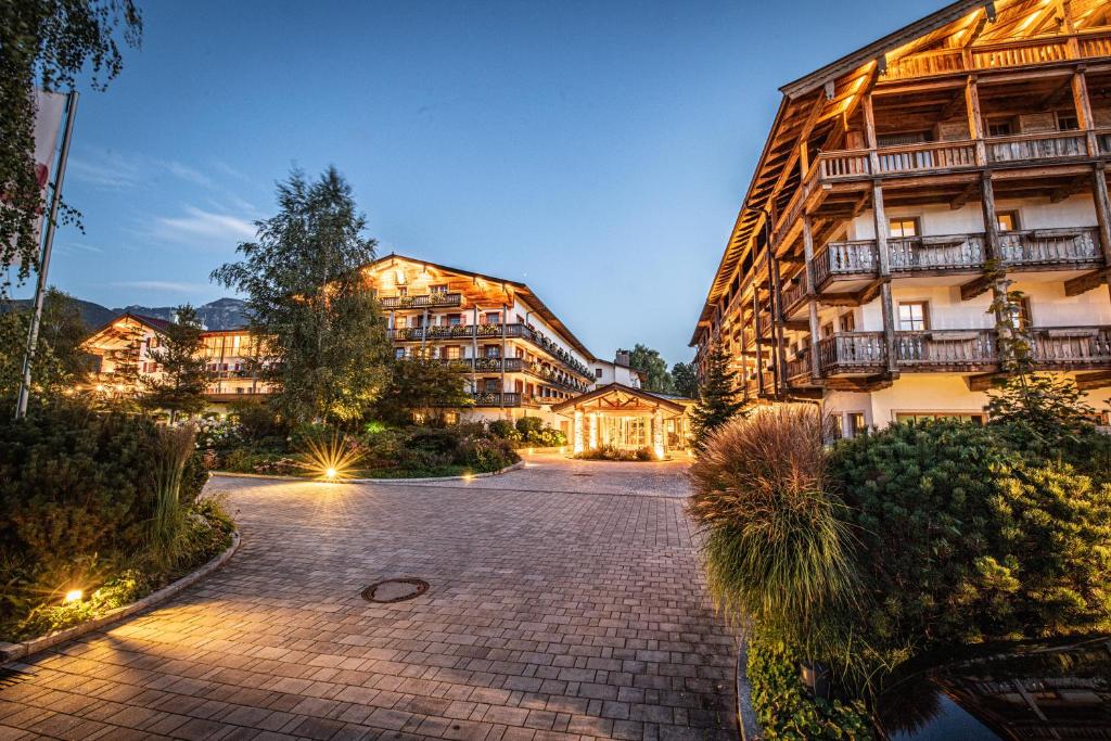 um grande edifício de apartamentos com uma entrada de tijolos em Das Achental Resort em Grassau