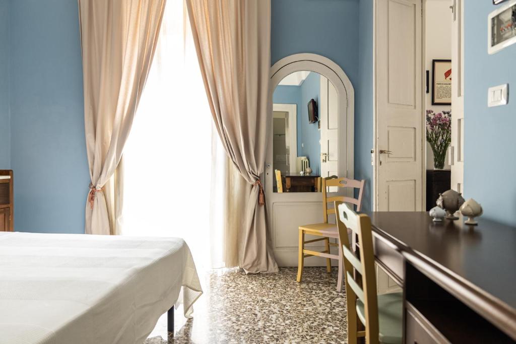a bedroom with a bed and a desk and a mirror at Palazzo Dante B&B Racale in Racale