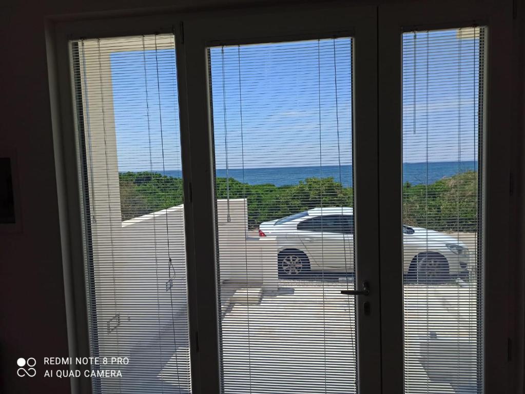 una ventana con vistas a un coche en un aparcamiento en case di piero, en Lido Marini