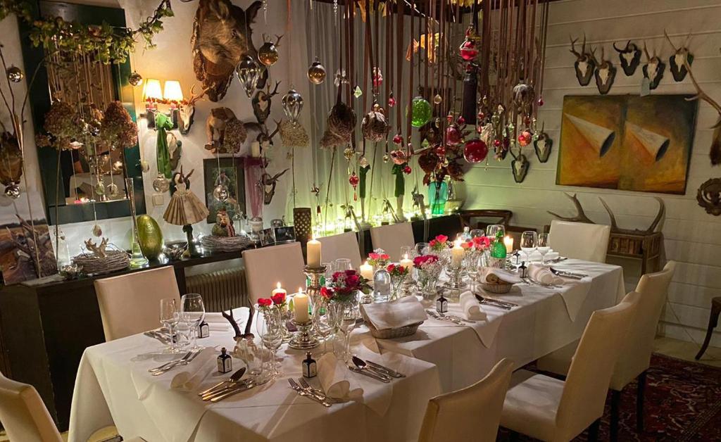 ein Esszimmer mit einem Tisch mit weißen Tischdecken und Kerzen in der Unterkunft Gasthof Gerlinde Gibiser in Heiligenkreuz im Lafnitztal
