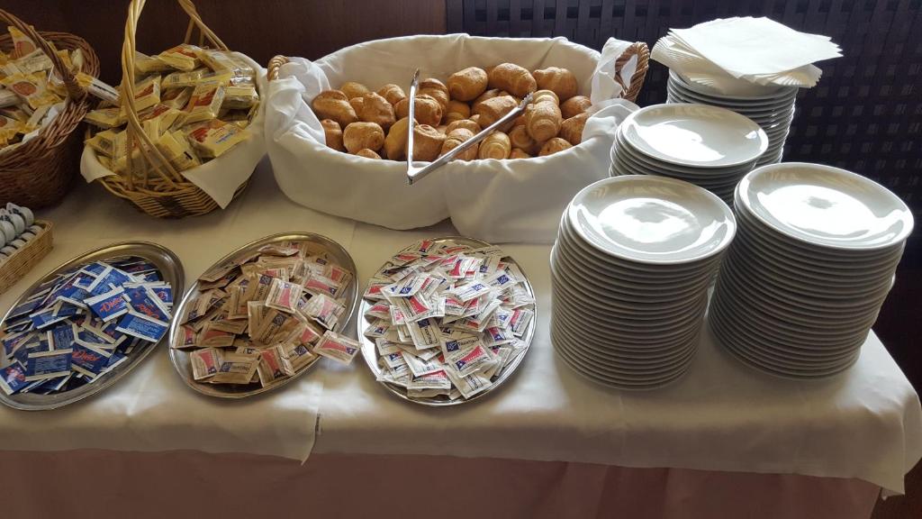 a table topped with plates and baskets of food at Hotel Cristallo in Madonna di Campiglio