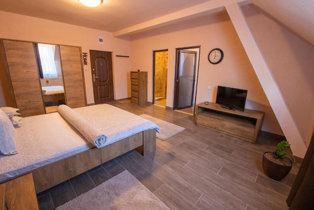 a large bedroom with a bed and a television at Braun Residence in Săcele