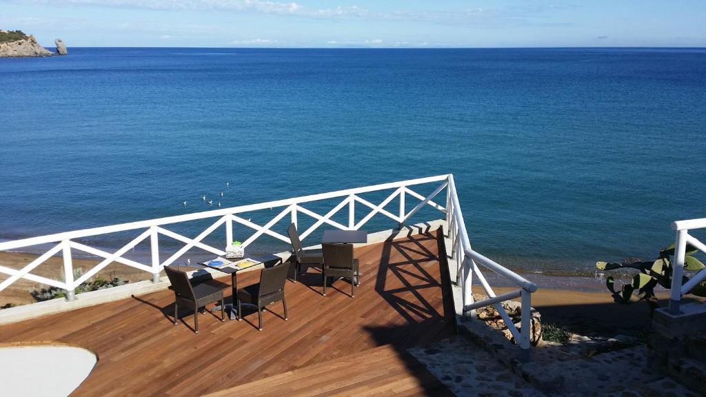 a balcony with a table and chairs overlooking the ocean at Le poste di Simplicio in Campese