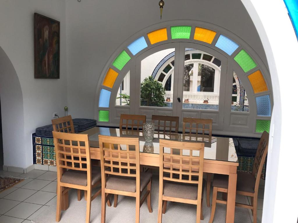a dining room with a table and chairs and a window at Villa Phoenicia in Hammamet