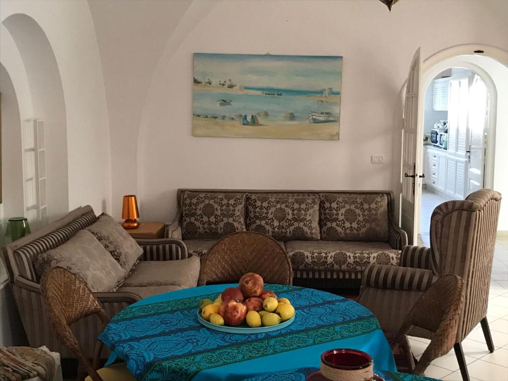 a living room with a couch and a table with fruit on it at Villa Phoenicia in Hammamet