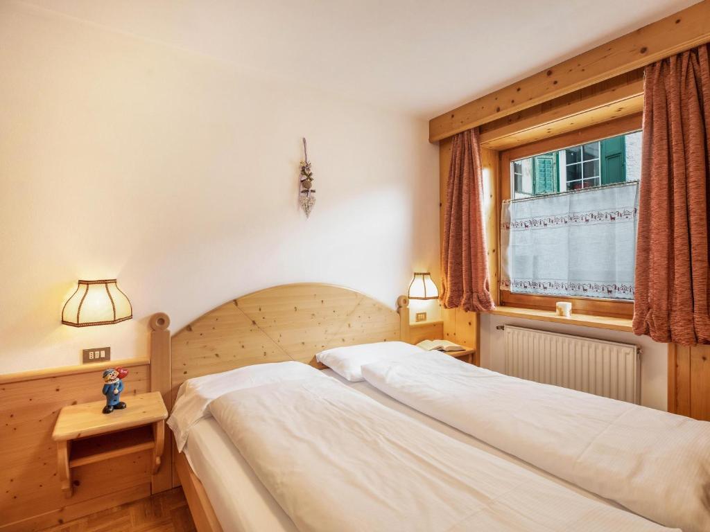 a bedroom with two beds and a window at Ciasa Lino Rotic in Pozza di Fassa