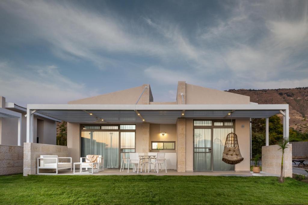 a house with a patio with a table and chairs at Ein Gev Holiday Resort in En Gev