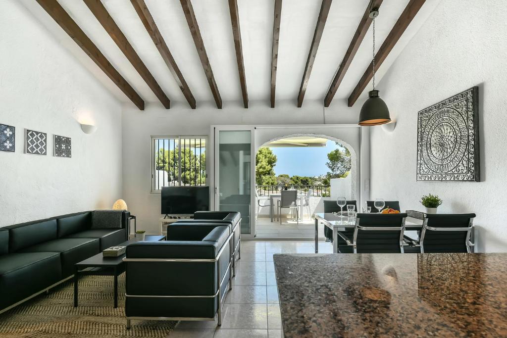 a living room with couches and a table at Modern stylish bungalow in Moraira in Moraira