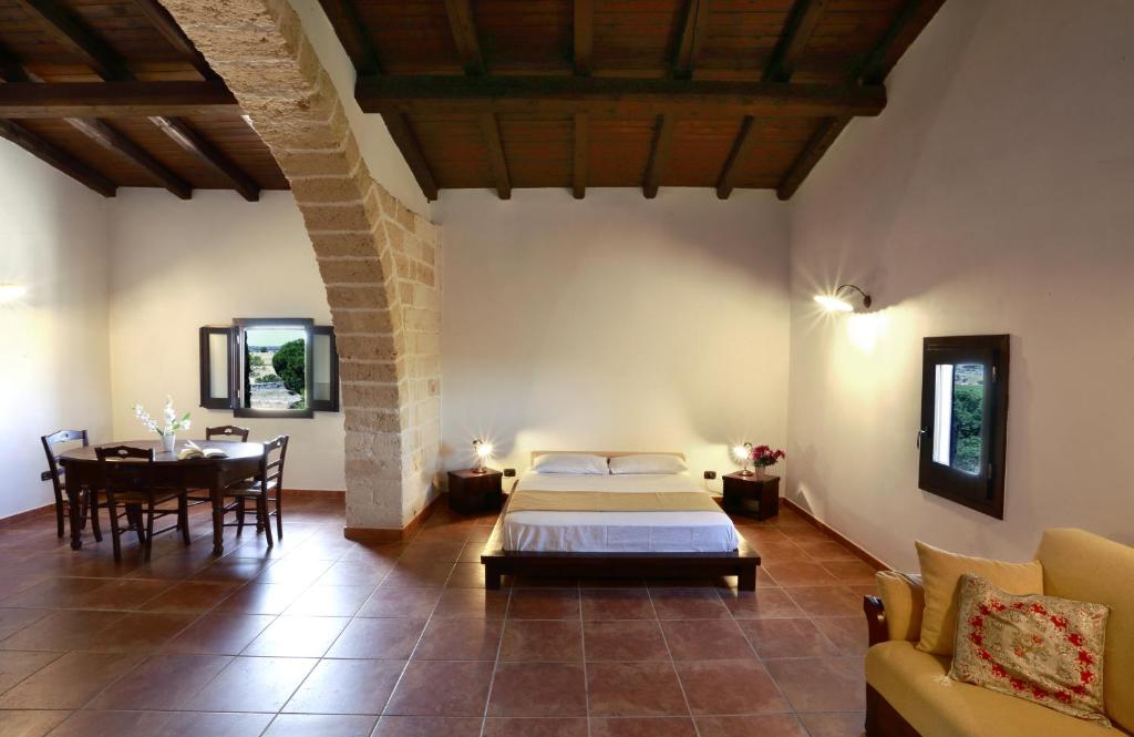 a bedroom with a bed and a table in a room at Masseria Nucci - Autentica Dimora Storica in Nardò