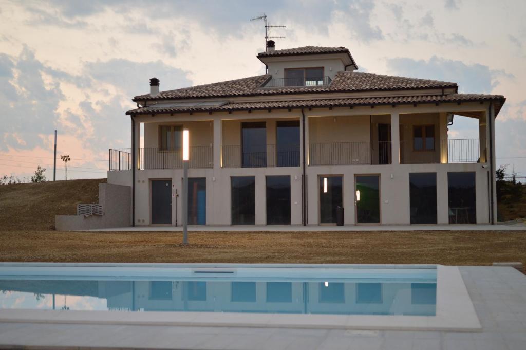 una casa con piscina frente a ella en RESORT REIS country house en Pineto