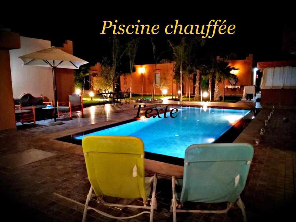 - deux chaises assises à côté de la piscine la nuit dans l'établissement Superbe villa marrakech, à Marrakech