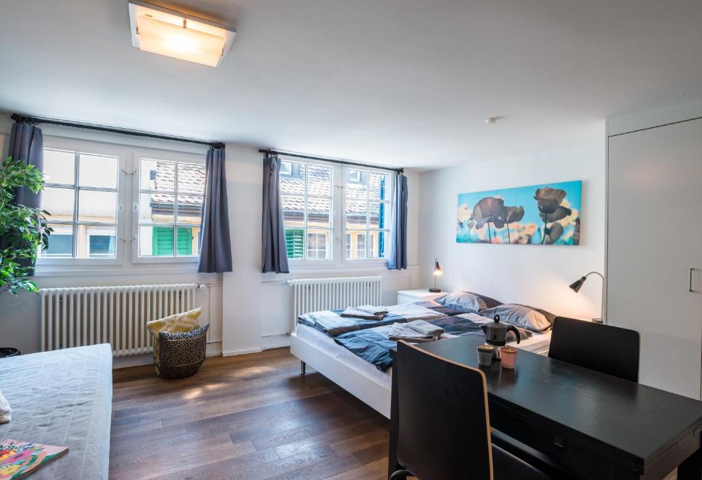 um quarto com uma cama, uma secretária e uma mesa em HITrental Schmidgasse - Apartments em Zürich