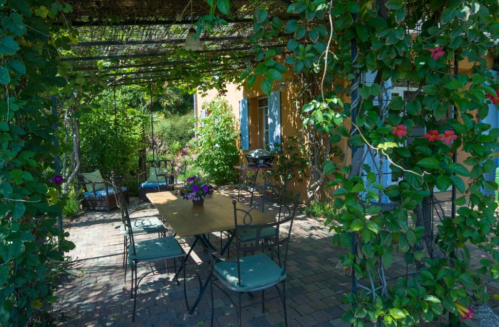 ラ・ロンド・レ・モールにあるHouse With Garden And Sea Viewのパティオ(パーゴラの下にテーブルと椅子付)
