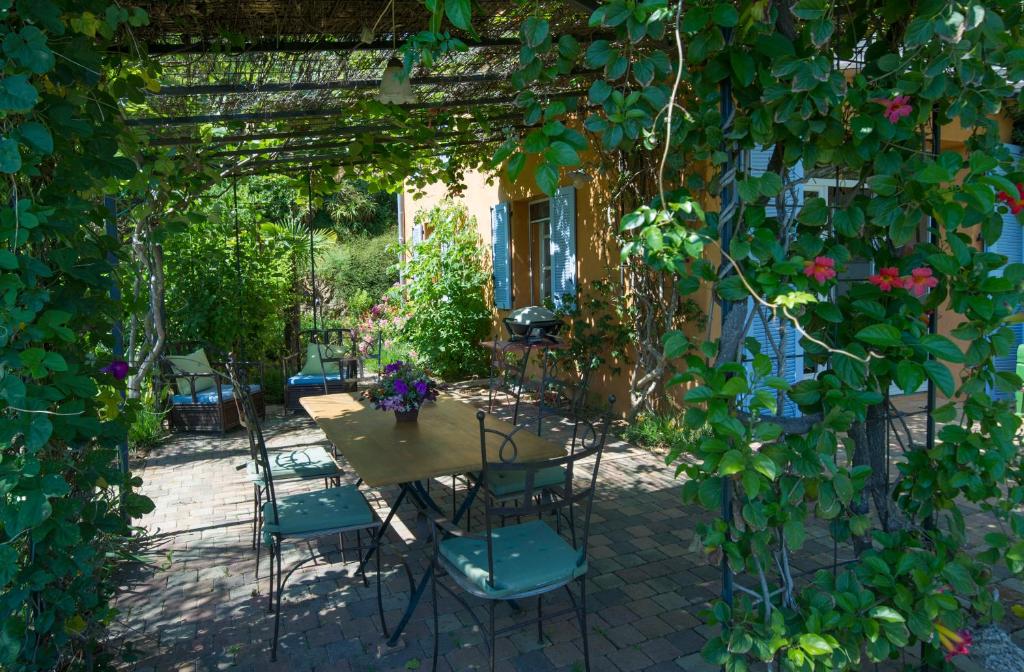 a patio with a table and chairs under a pergola at House With Garden And Sea View in La Londe-les-Maures