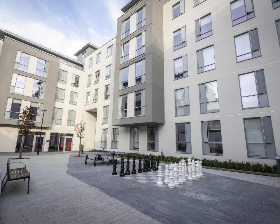 un grande edificio con una partita a scacchi nel cortile di JOIVY Affordable Dublin Thomas Street - Adults only a Dublino
