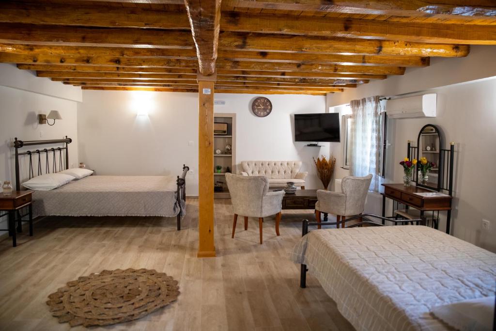 um quarto com 2 camas, uma mesa e cadeiras em Ainos Retreat em Kefalonia