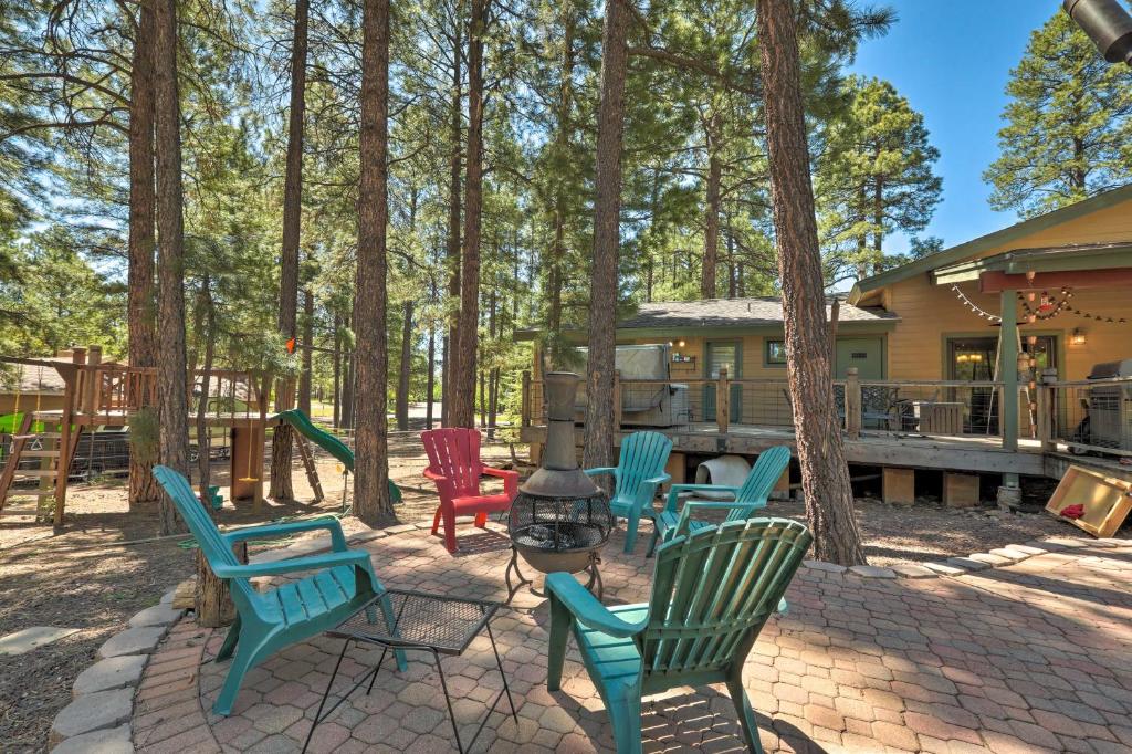 弗拉格斯塔夫的住宿－Flagstaff Mountain Oasis with Hot Tub 2 Mi to Dtwn!，庭院设有椅子、烧烤架和树木