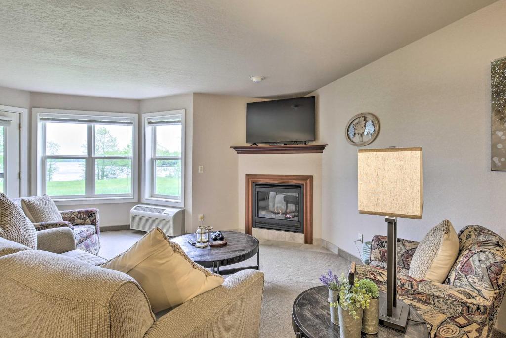 a living room with a fireplace and a tv at Lakefront Birchwood Condo with Pool and Hot Tub! in Birchwood