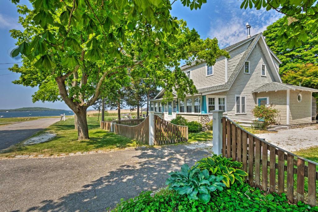 uma casa na praia com uma cerca e uma árvore em Common Fence Point Cottage with Ocean Views! em Portsmouth