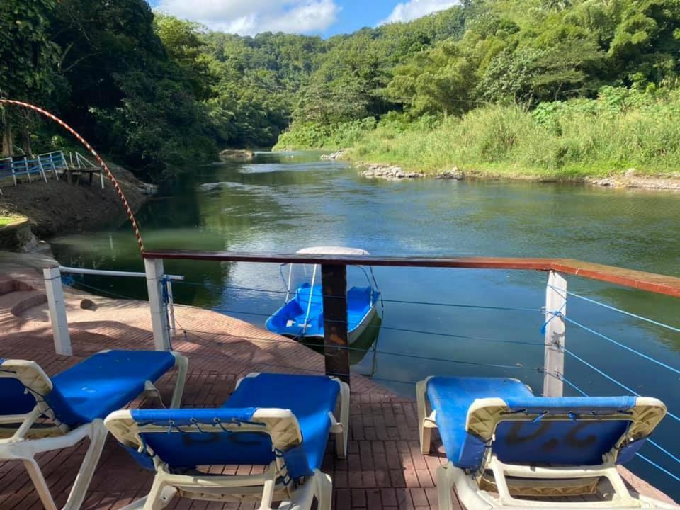 ein Boot auf einem Fluss mit Stühlen auf dem Deck in der Unterkunft Tapicoa Village Retreat in Saint Mary