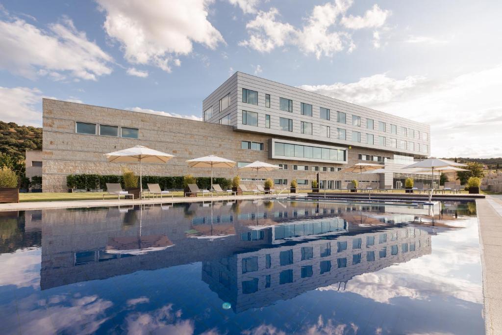 ein Gebäude mit einem Pool vor einem Gebäude in der Unterkunft Valbusenda Hotel Bodega & Spa in Toro