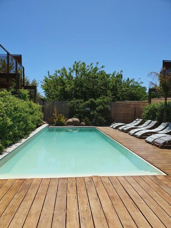 - une piscine sur une terrasse en bois avec des chaises dans l'établissement Appartement 3 pièces 4-6 personnes, clim, terrasse et piscine, au Cap d'Agde
