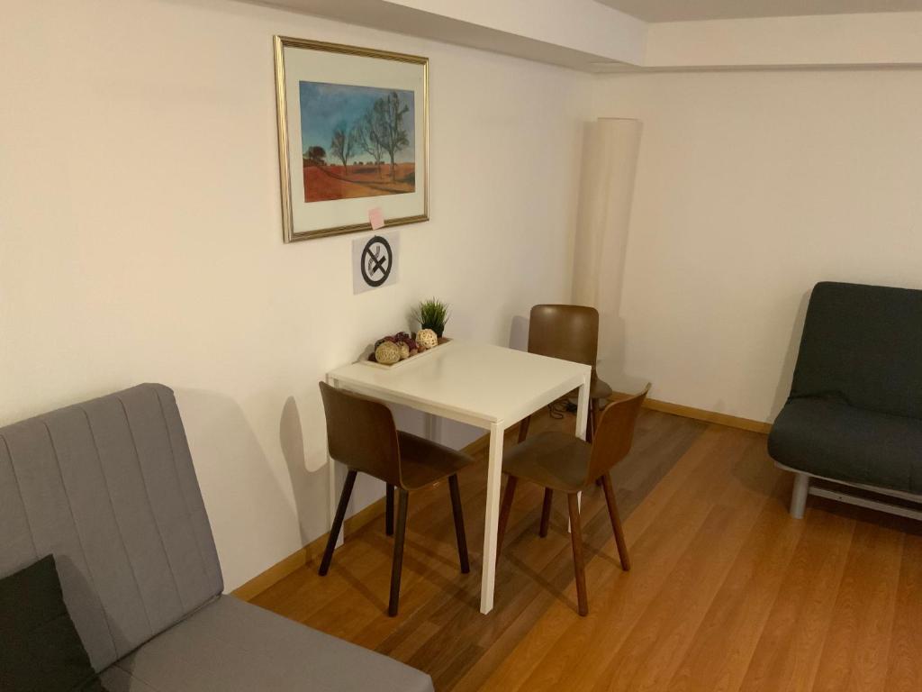 una habitación con una mesa y sillas blancas y una pintura en ruhiges privates Zimmer in Freiburg, zentrumsnah, Nähe Europapark, en Freiburg im Breisgau