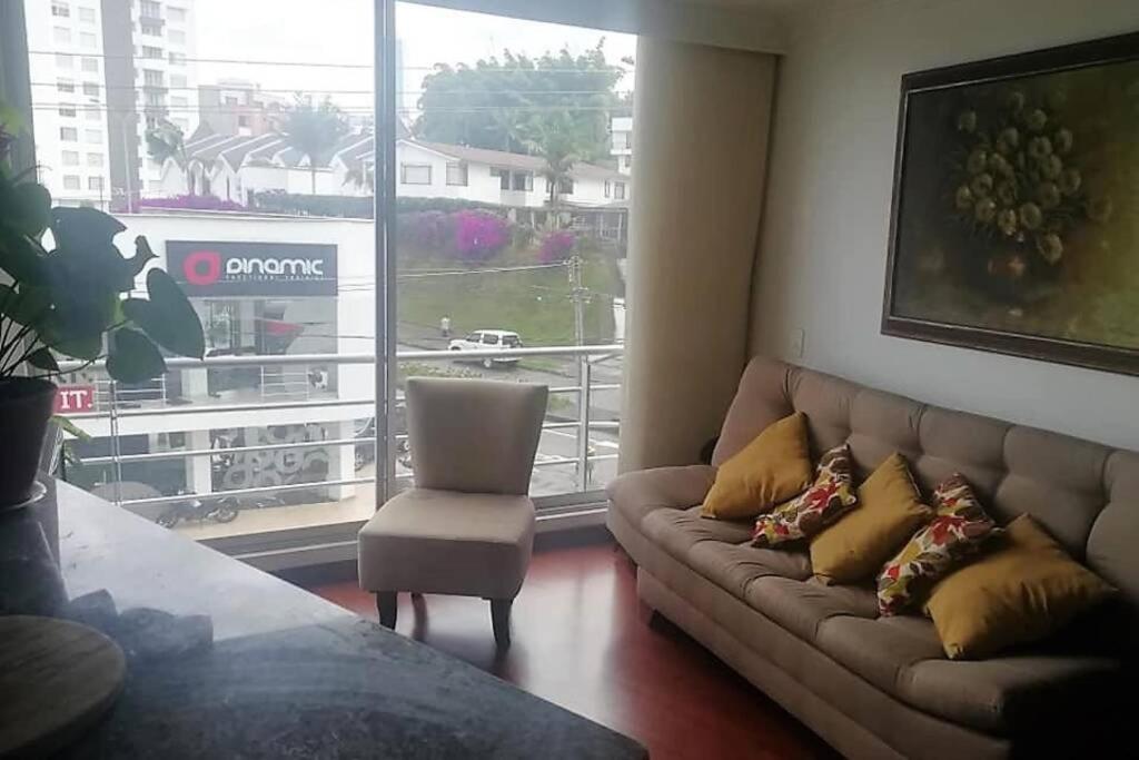 a living room with a couch and a chair and a window at Palermo, Acogedor apartamento en Zona Rosa in Manizales