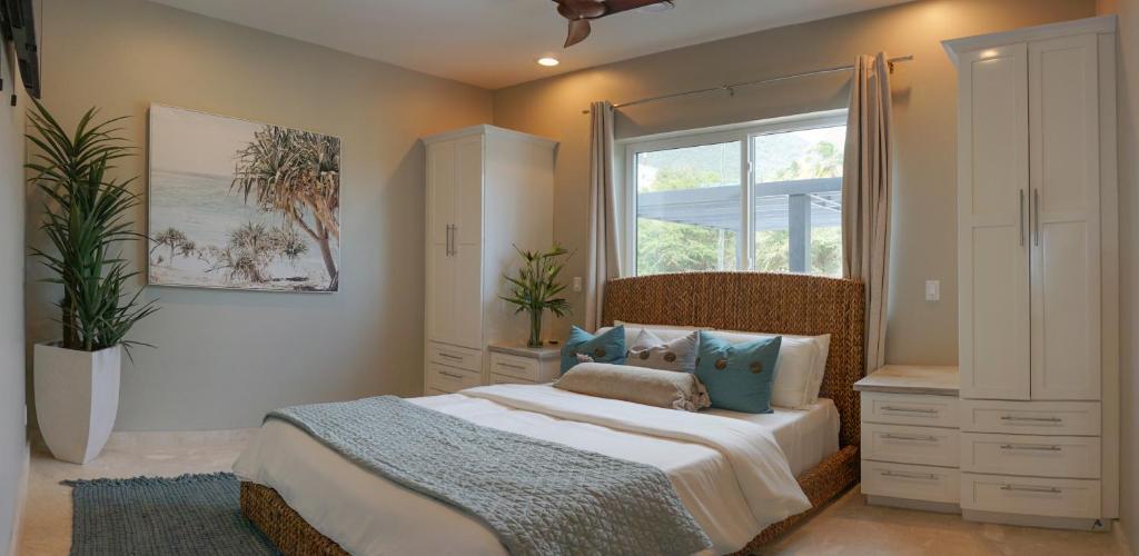 um quarto com uma cama grande e uma janela em Sunset Reef St. Kitts em Ottleyʼs