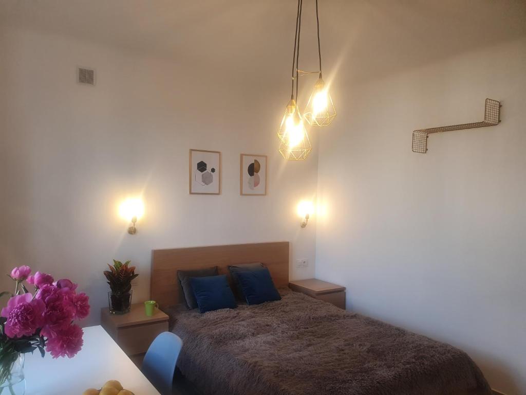 Schlafzimmer mit einem Bett mit blauen Kissen und Lampen in der Unterkunft Flat Femina Street in Warschau