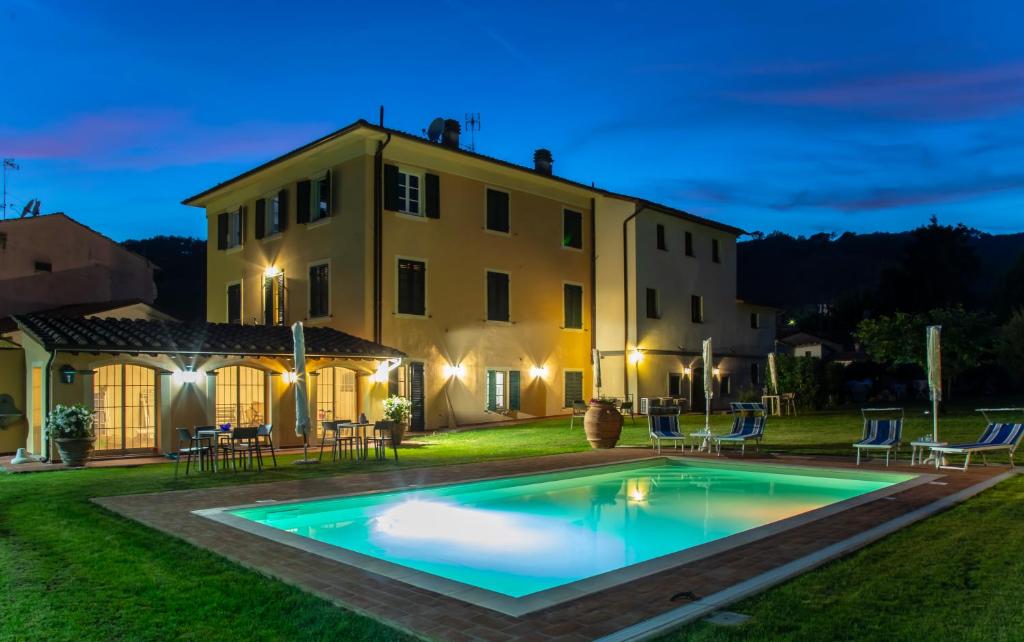 a villa with a swimming pool in front of a house at Garden Relays Villa Rosy in Massarosa