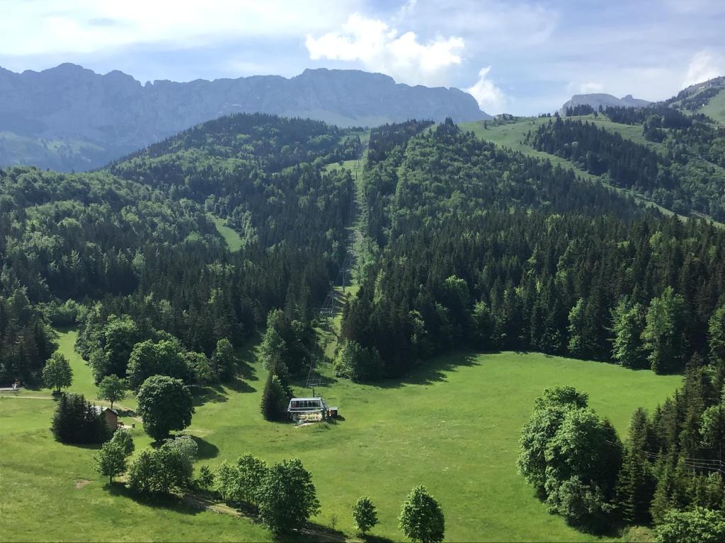 a house in a field in the mountains at Grand Studio VILLARD DE LANS Les Glovettes in Villard-de-Lans