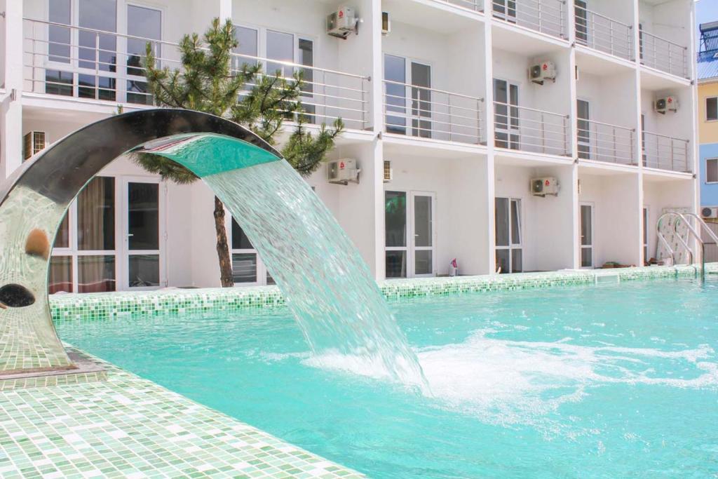 a fountain in a pool in front of a building at OSTRIV Hotel in Zatoka