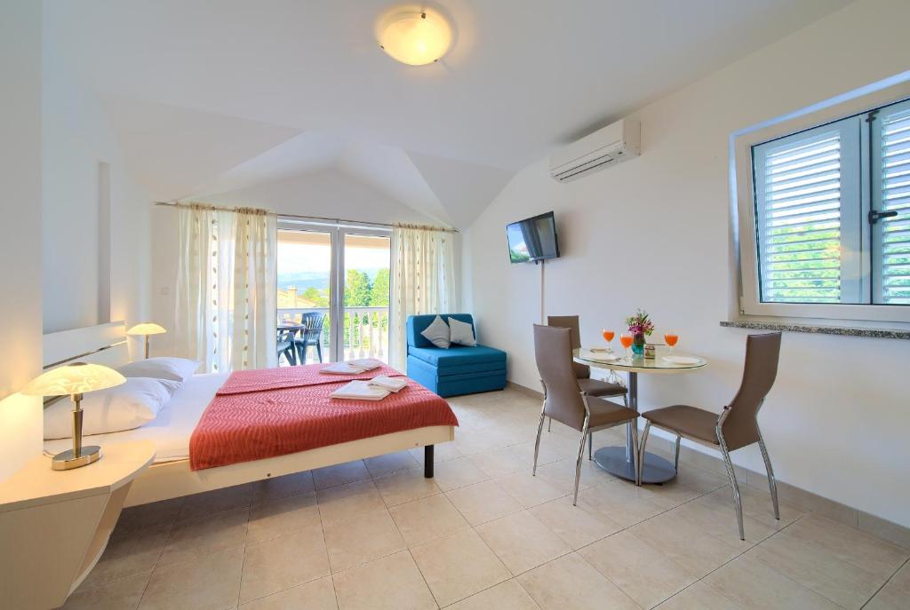 een slaapkamer met een bed en een tafel en stoelen bij Apartments Ivica Krk Island in Šilo