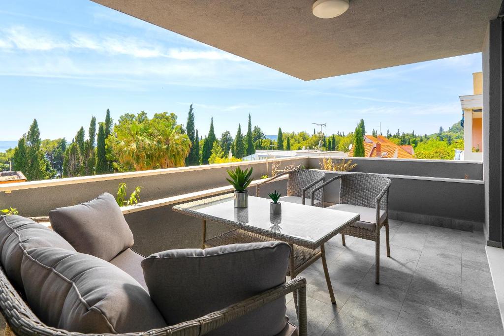 sala de estar con sofá y mesa en el balcón en Luxury Bella Vista Holidays @ Kasuni Beach, en Split