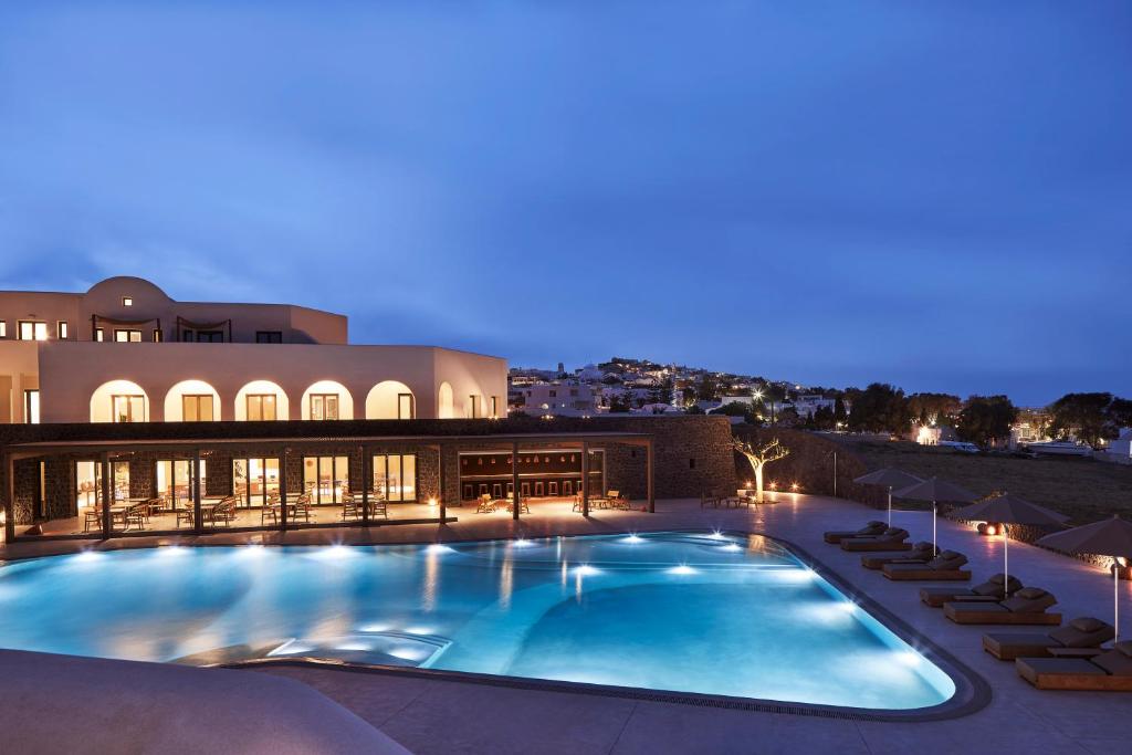 a large swimming pool in a hotel at night at Orama Hotel & Spa in Fira