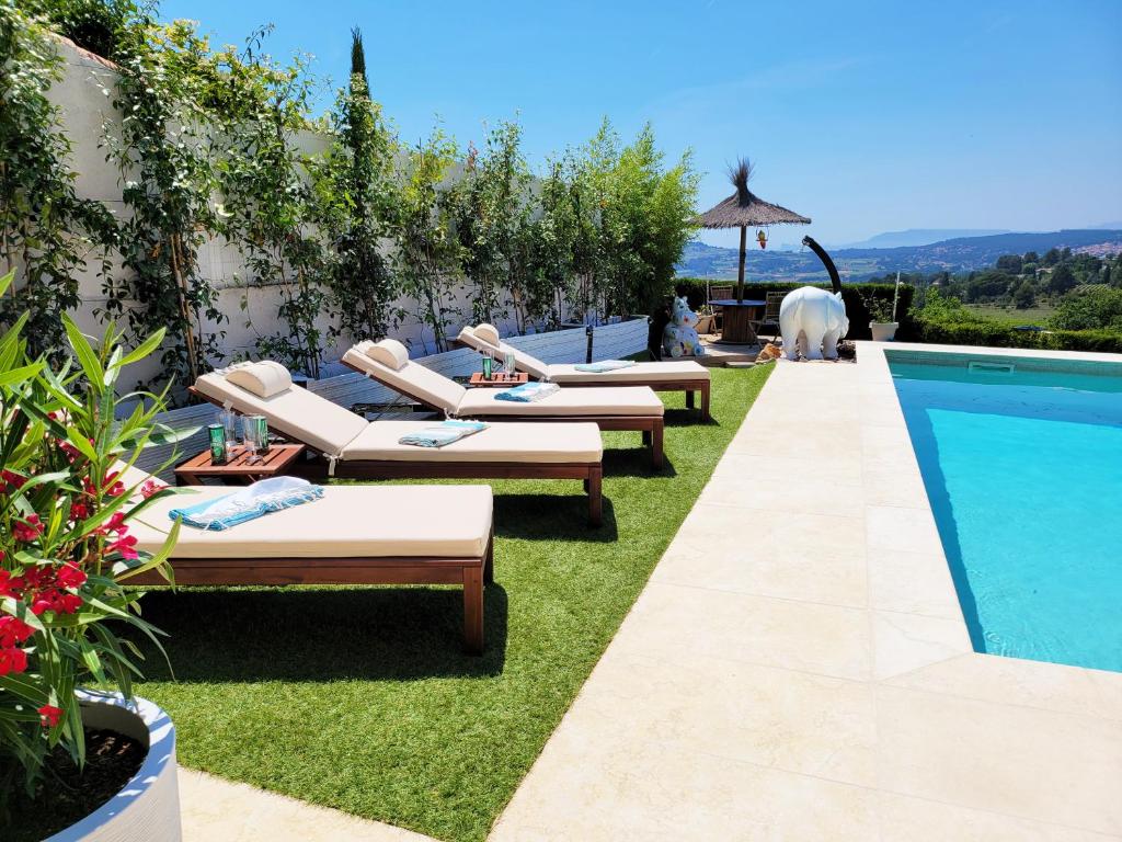 - une rangée de chaises longues à côté de la piscine dans l'établissement Le Nid Bleu, au Beausset