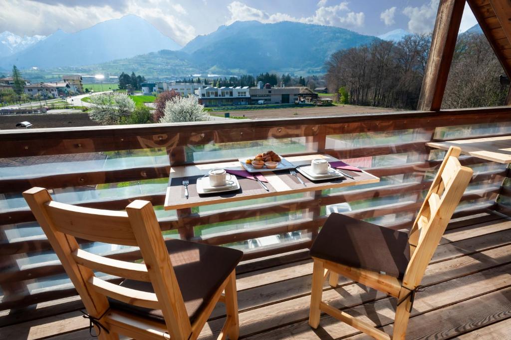 - une table et des chaises sur une terrasse avec vue sur les montagnes dans l'établissement B&B da Sabry e Gian, à Comano Terme