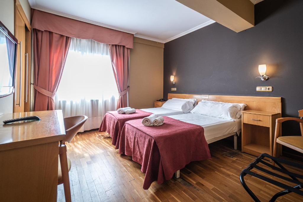 a hotel room with two beds and a window at Hotel Silva in Ferrol